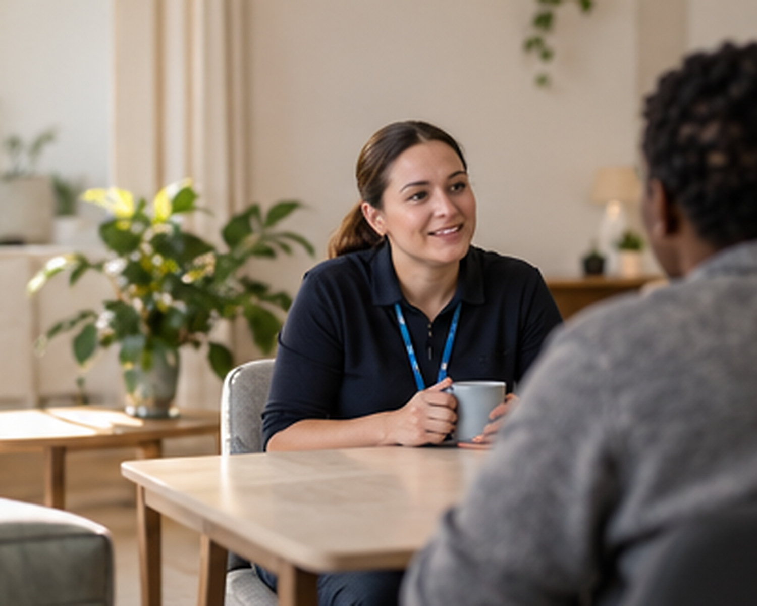 A support worker talking with a resident at a kitchen table
